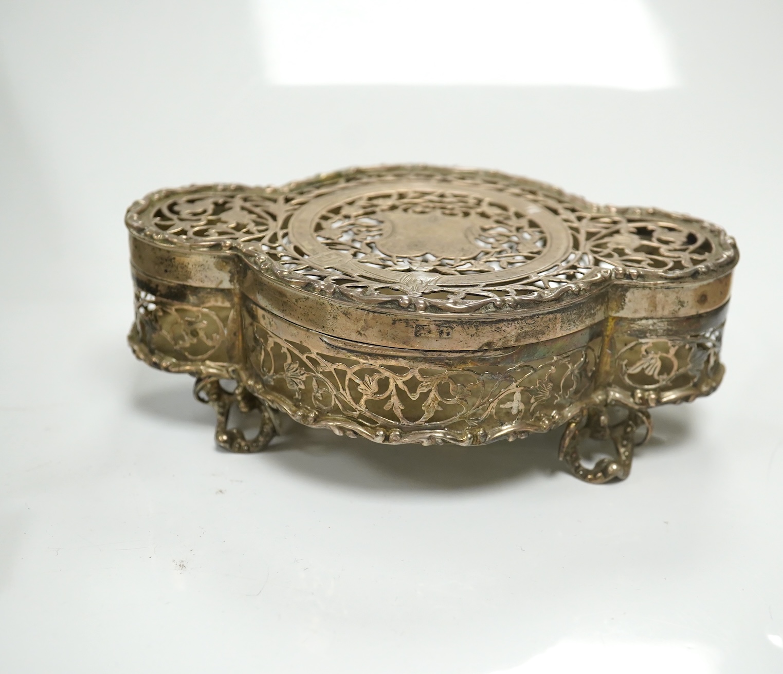 A George V pierced silver pot pourri box, by Nathan & Hayes?, Birmingham, 1916, 13.2cm, together with a silver mounted shaving brush and a cased silver mounted clothes brush. Condition - fair